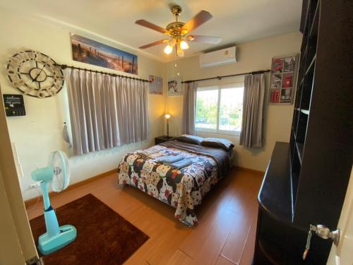a bedroom with a bed and a fan and a window at Captivating 3-Bed Villa in Muang Pattaya in Nong Prue