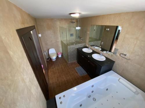 a large bathroom with two sinks and a tub at Captivating 3-Bed Villa in Muang Pattaya in Nong Prue