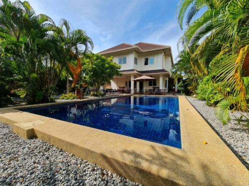 a swimming pool in front of a house at Captivating 3-Bed Villa in Muang Pattaya in Nong Prue