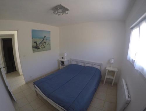 a bedroom with a blue bed in a white room at Gîte en Béarn entre Océan et Montagne classé 4 Etoiles in Labeyrie