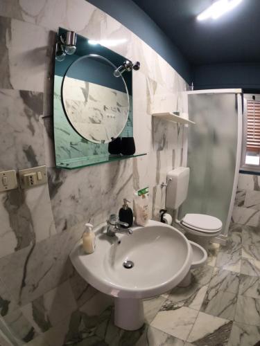 uma casa de banho com um lavatório, um WC e um espelho. em Baggio House em Cadarese