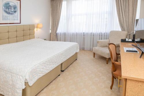 a hotel room with a bed and a chair at Grand Hotel Cravat in Luxembourg