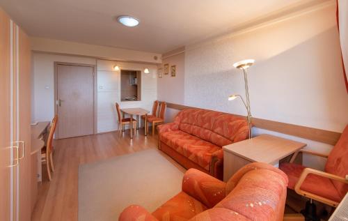 a living room with a couch and a table at Hotel Barátság in Hajdúszoboszló