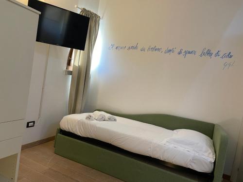 a bedroom with a bed with a sign on the wall at Splendida camera familiare con lucernario a 500 mt dal mare in Marina di Carrara