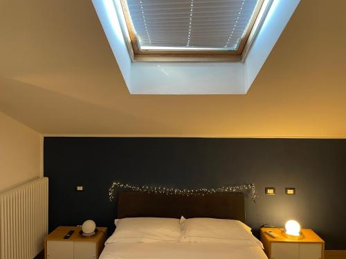 a bedroom with a large bed with a skylight at Splendida camera familiare con lucernario a 500 mt dal mare in Marina di Carrara