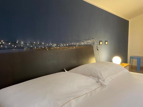 sypialnia z białym łóżkiem z lampkami powyżej w obiekcie Splendida camera familiare con lucernario a 500 mt dal mare w mieście Marina di Carrara