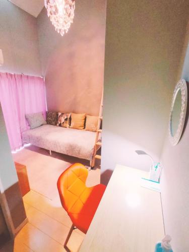 - un salon avec un canapé et une chaise dans l'établissement MeMe Inn - Vacation STAY 10900, à Saitama
