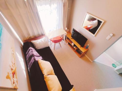 una pequeña sala de estar con sofá y TV en MeMe Inn - Vacation STAY 10899 en Saitama