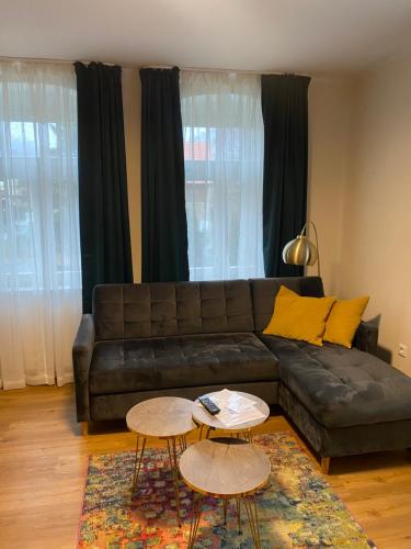 a living room with a leather couch and two tables at Pension & Café Abendröte in Kurort Oybin
