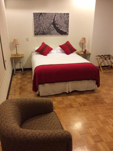 a bedroom with a large bed and a chair at Legacy Boutique Hotel in Quesada