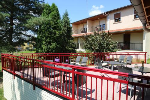 d'un balcon avec une balustrade rouge, des tables et des chaises dans l'établissement Relais Vosgien - Hôtel Restaurant "la Table de Sophia", à Saint-Pierremont