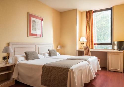 Una habitación de hotel con dos camas y una ventana. en Sunotel Aston, en Barcelona