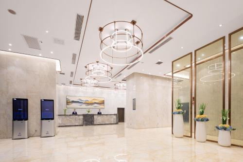 a large lobby with a reception desk and a large chandelier at Shenzhen Bay Hisoar Hotel in Shenzhen