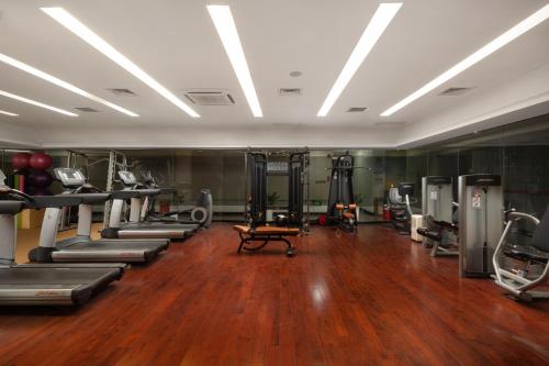 a gym with treadmills and machines in a room at Shenzhen Bay Hisoar Hotel in Shenzhen
