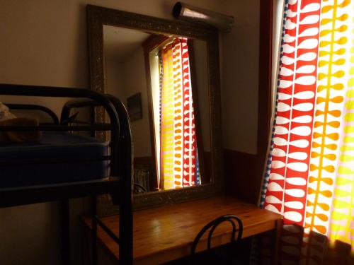 - un miroir installé sur une table en bois dans une chambre dans l'établissement GLOBE-TROTTER & BACKPACKERS HOSTEL, à Québec