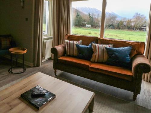 a living room with a couch and a large window at Island View House in Ballachulish