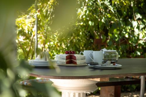 a table with a cake and coffee cups on it at Zervos Apartments Bouka in Lefkímmi