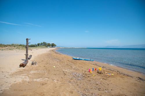 a sandy beach with boats and toys on the shore at Zervos Apartments Bouka in Lefkímmi