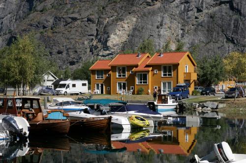 a group of boats in a marina with a house at Lærdal Ferie- og Fritidspark in Lærdalsøyri
