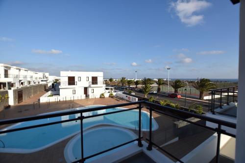 uma vista a partir da varanda de um edifício com piscina em Mirador del Mar Lanzarote em Costa Teguise