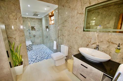 y baño con lavabo, aseo y ducha. en SEA SPLASH SELF CATERING And La Petite Maison, en Grand Anse