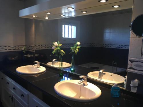 a bathroom with three sinks and a large mirror at Casa Paula in Yaiza