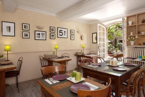 a dining room with tables and chairs and a window at Hotel De L'Atelier in Villeneuve-lès-Avignon