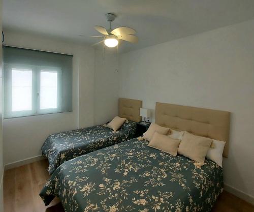 1 dormitorio con 2 camas y ventilador de techo en Casa Rural Benamahoma, en Benamahoma
