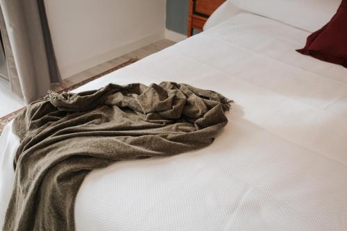 a blanket sitting on top of a bed at Casa da Catedral Jerónimo in Badajoz