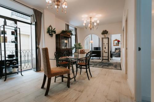 a dining room and living room with a table and chairs at Casa da Catedral Jerónimo in Badajoz