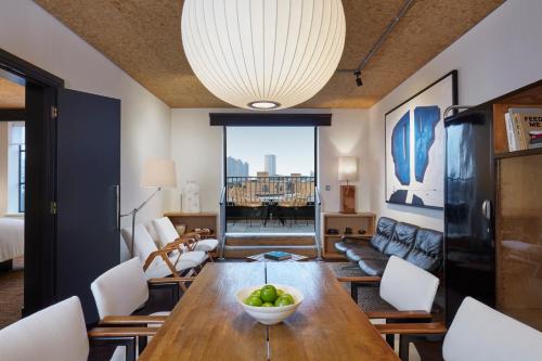 a living room with a wooden table with a bowl of fruit on it at One Hundred Shoreditch in London