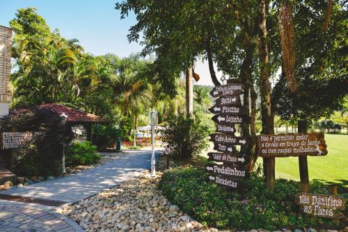 a street sign with many signs in a park at Fazzenda Park Resort in Gaspar