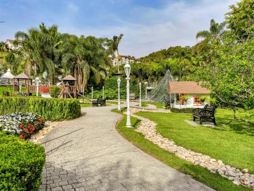 a walkway through a park with a playground at Fazzenda Park Resort in Gaspar