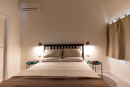 a bedroom with a large bed with two side tables at Avolio apartment in Noto