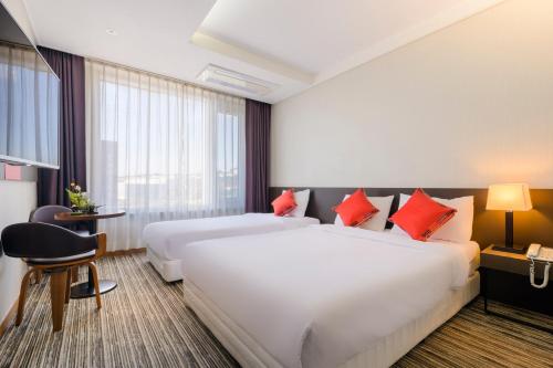 Ένα ή περισσότερα κρεβάτια σε δωμάτιο στο Shin Shin Hotel Jeju Worldcup