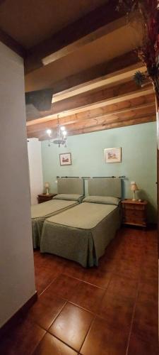 a bedroom with a bed in a room with wooden ceilings at La Casa del Marques in Cazalegas