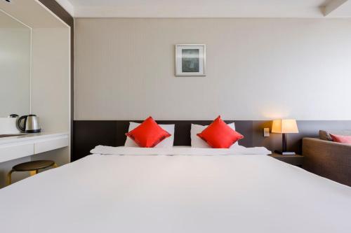 Ένα ή περισσότερα κρεβάτια σε δωμάτιο στο Shin Shin Hotel Jeju Worldcup