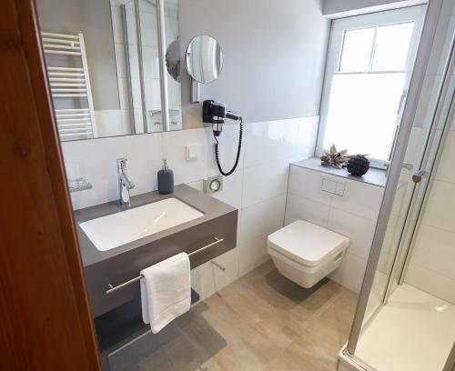 a bathroom with a sink and a toilet and a mirror at Gästehaus Warsteiner Welt in Warstein