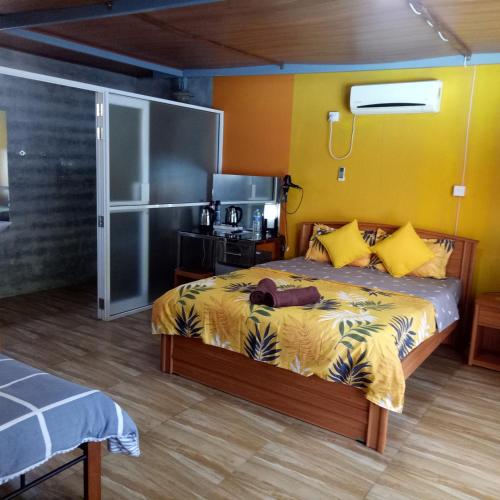 a bedroom with a bed with a yellow wall at Palms Villa in Negombo