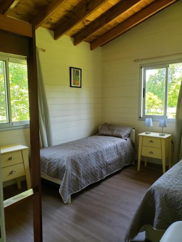 a bedroom with two beds and two windows at CARPINCHO AMARILLO in Tigre