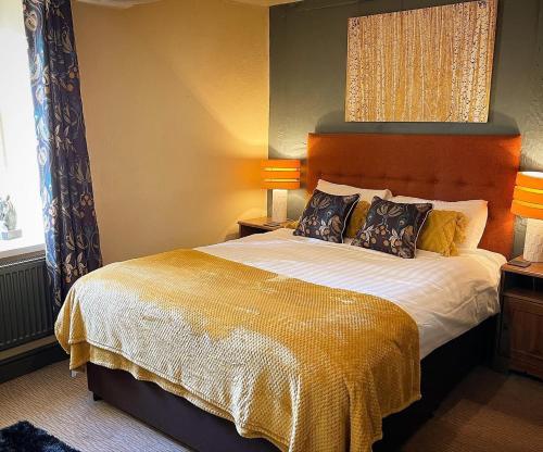 a bedroom with a large bed with two lamps at The Coach and Horses Inn in Chepstow
