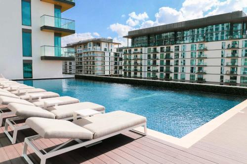 a swimming pool with lounge chairs on a building at STAY BY LATINEM Luxury 1BR Holiday Home G6524 near Burj Khalifa in Dubai