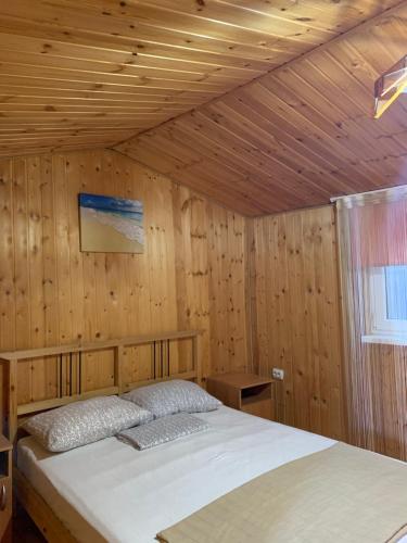 ゴルビツカヤにあるГостевой дом «Ласковый берег»の木製の部屋にベッド1台が備わるベッドルーム1室があります。
