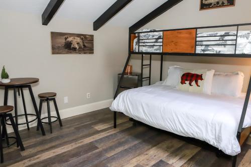 a bedroom with a bed and a table at Gunstock Inn & Suites in Gilford