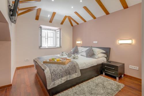 a bedroom with a bed with a tray of fruit on it at Palace Suites Heritage Hotel - Adults Only in Split