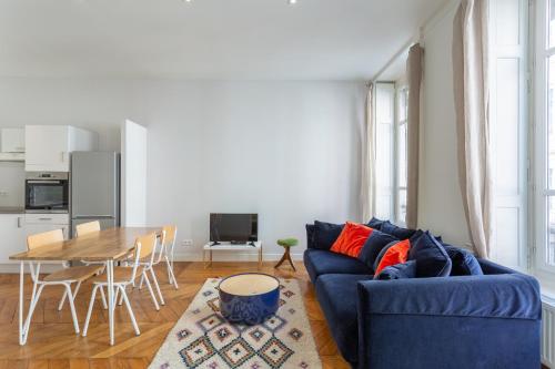 uma sala de estar com um sofá azul e uma mesa em DIFY Le Velvet - Bellecour em Lyon