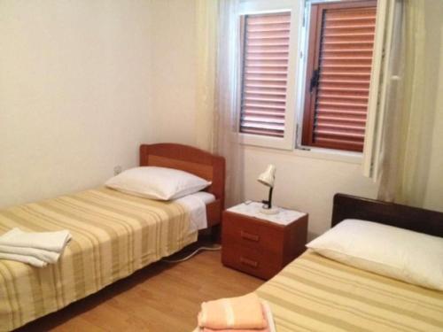 a room with two beds and a table with a lamp at Holiday home in Sali with sea view, terrace 4420-1 in Sali