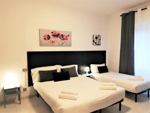 two beds in a room with white sheets at Pero Apartment - Fiera Milano in Pero