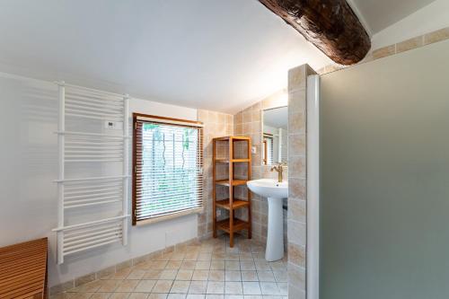 une salle de bain avec un lavabo et une fenêtre dans l'établissement La Maison d'à Côté, à Mus