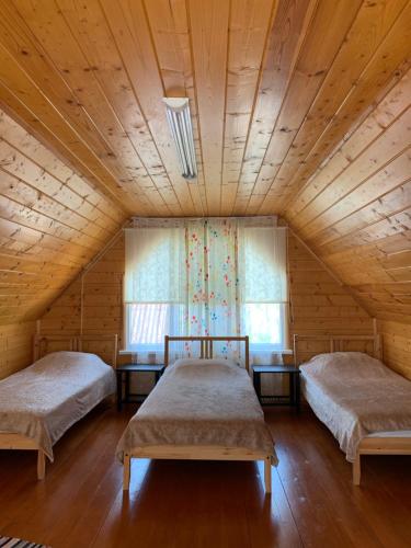 ゴルビツカヤにあるКоттеджи «Ласковый Берег»の木製天井のドミトリールームのベッド2台分です。